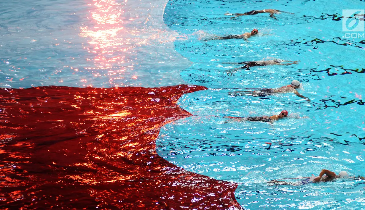 Sejumlah perenang menarik bendera Merah Putih saat pembukaan Indonesia Open Aquatic Championship 2017 di Stadion Aquatic GBK, Jakarta, Selasa (5/12). Ajang ini merupakan test event jelang Asian Games 2018. (Liputan6.com/Helmi Fithriansyah)