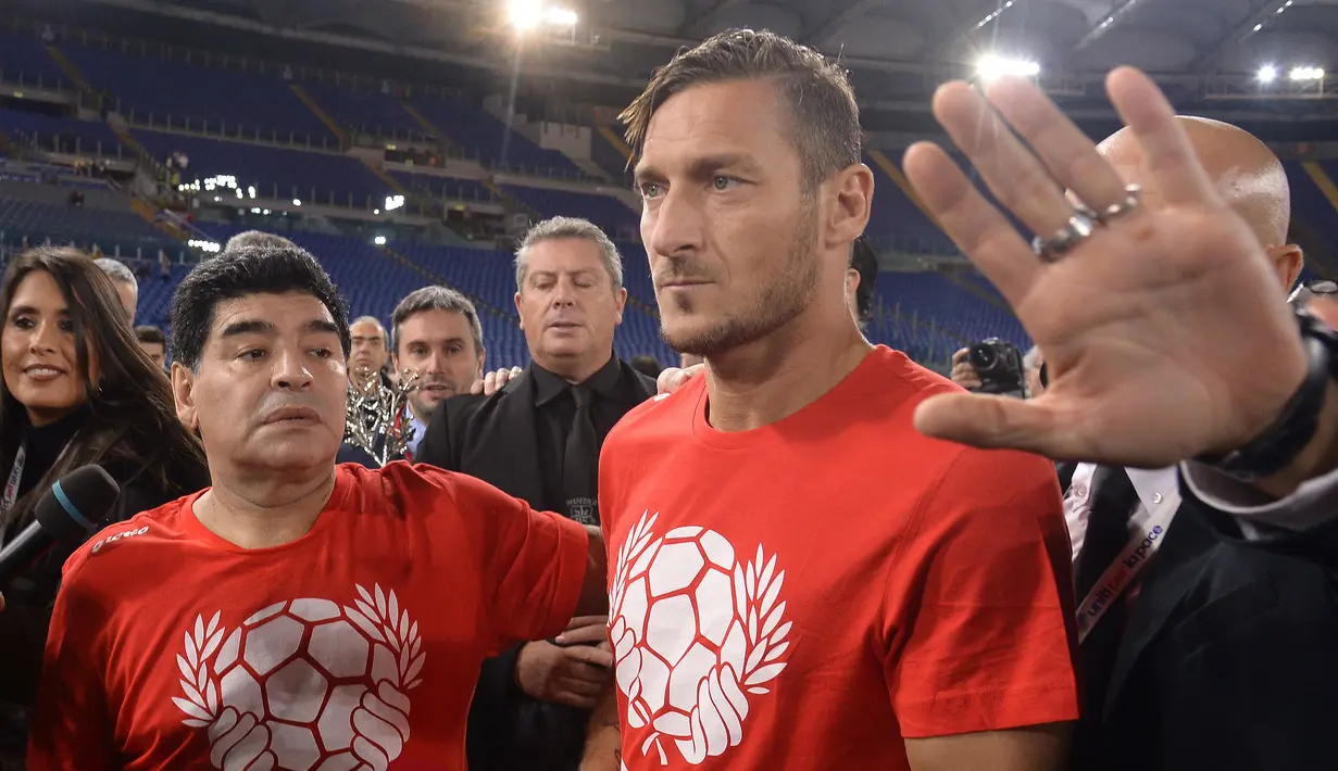 (12/10/2016) - Diego Maradona (kiri) berfoto bersama striker Italia dan kapten AS Roma, Francesco Totti sebelum pertandingan amal, "Match of Peace-United for Peace" di Olympic Stadium, Roma, Italia (AFP/Filippo Monteforte)