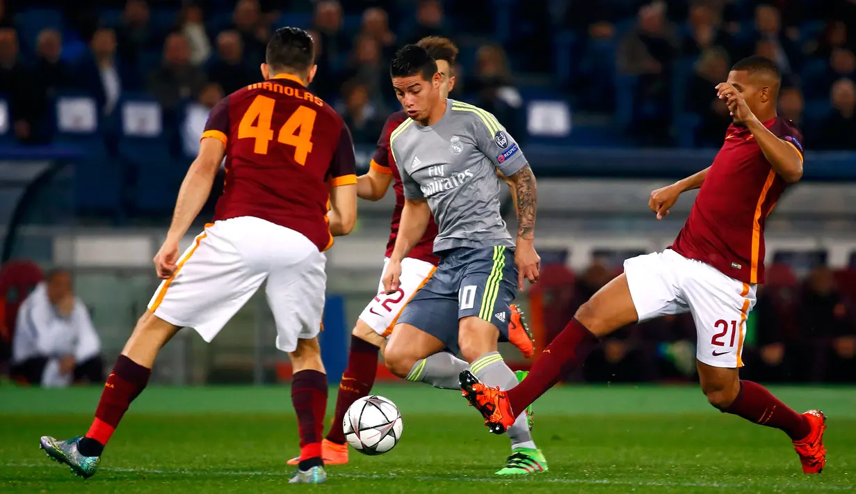 Gelandang Real Madrid, James Rodriguez (tengah) berusaha melewati tiga pemain AS Roma pada leg pertama 16 besar Liga Champions di Stadion Olimpico, Italia (18/2). Real Madrid menang atas AS Roma dengan skor 2-0. (REUTERS/Tony Gentile)