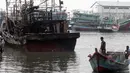 Dua orang lelaki melihat kapal yang terbakar di Pelabuhan Muara Angke, Jakarta, Jumat (27/2/2015). Diduga kebakaran disebabkan korsleting listrik. Kerugian ditaksir mencapai ratusan juta. (Liputan6.com/Johan Tallo)