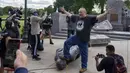 Anggota gerakan Indian Amerika Mike Forcia menginjak patung Christopher Columbus yang dirobohkan sekelompok massa di Minnesota State Capitol, St. Paul, Minnesota, Amerika Serikat, Rabu (10/6/2020). (Evan Frost/Minnesota Public Radio via AP)