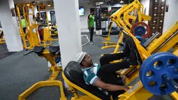 Seorang pria Muslim India saat berlatih di gym Ahmedabad Fitness Academy (AFA) di Ahmedabad (10/5/2019). Selama bulan suci Ramadhan, tempat gym ini tetap buka hingga larut malam untuk membiarkan anggota Muslim berolahraga setelah salat. (AFP Photo/Sam Panthaky)