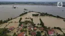 Foto udara suasana pemukiman warga yang terendam banjir menggunakan kamera nir-awak di Desa Karangligar dan Dusun Pengasinan kecamatan Teluk Jambe Barat, Kabupaten Karawang, Selasa (6/12/2022).  Banjir yang terjadi setelah hujan deras yang mengguyur sejak Minggu (4/12/2022) mulai berangsur surut. (merdeka.com/Imam Buhori)