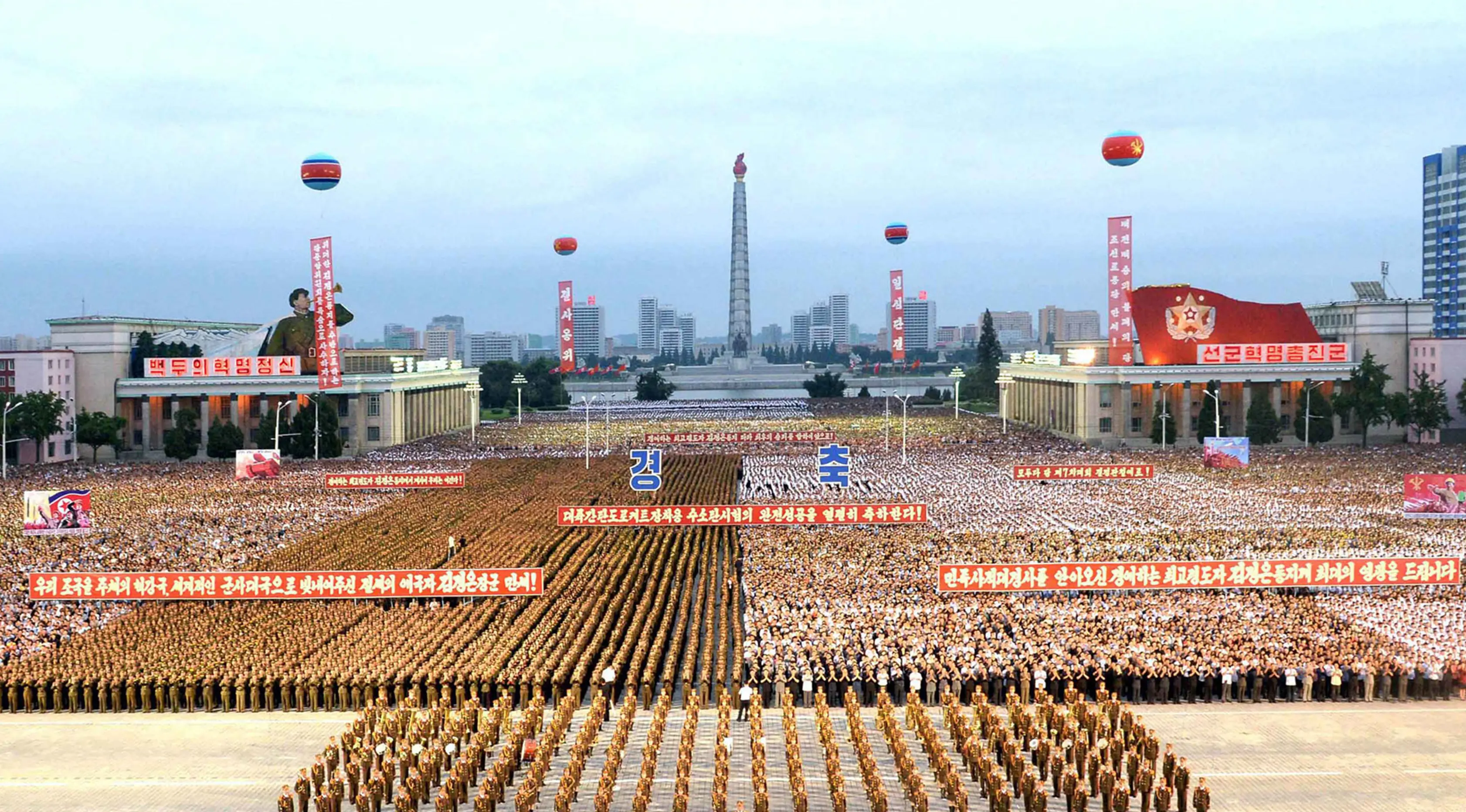 Warga sipil dan personel militer berkumpul di Kim Il Sung Square, Pyongyang untuk merayakan kesuksesan peluncuran bom hidregon antarbenua, Rabu (6/9). Korut menyatakan berhasil melakukan uji coba bom hidroben pada Minggu lalu. (STR/KCNA VIS KNS/AFP)