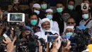 Rizieq Shihab (tengah) memberi keterangan sesaat sebelum masuk gedung utama Mapolda Metro Jaya, Jakarta, Sabtu (12/12/2020). Rizieq Shihab akan menjalani pemeriksan sebagai tersangka penghasutan dan kerumunan di tengah pandemi Covid-19. (Liputan6.com/Helmi Fithriansyah)