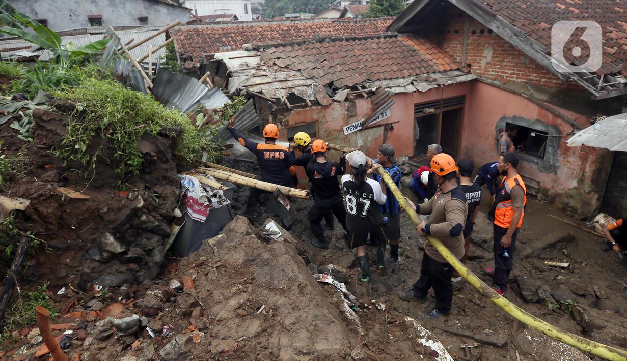 Petugas membersihkan material longsor pada areal pemancingan yang menyebabkan satu orang meninggal dunia di Gang Kepatihan, Kelurahan Kebon Kelapa, Kecamatan Bogor Tengah, Bogor, Jawa Barat, Rabu (12/10/2022). Longsor yang terjadi pada kemarin sore menyebabkan sembilan pemancing tertimbun tanah namun selamat dan seorang anggota kepolisian meninggal. (merdeka.com/Arie Basuki)