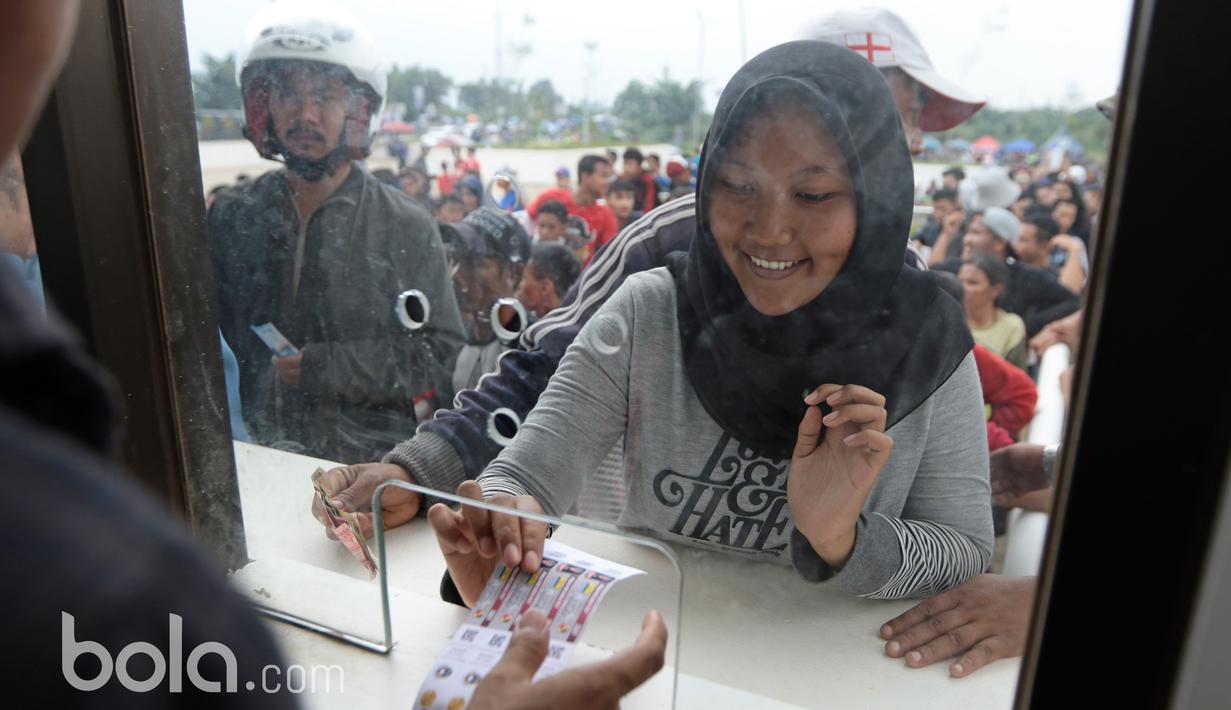 Ekspresi senang seorang suporter saat menerima tiket yang dibelinya pada loket pembelian tiket di Stadion Pakansari, Bogor, Sabtu (11/3/2017). (Bola.com/Nicklas Hanoatubun)