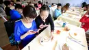 Sejumlah pengunjung menikmati hidangan serba Hello Kitty disebuah restoran di Shanghai, Cina, April 9, 2016. Restoran ini merupakan restoran pertama yang resmi memakai Hello Kitty sebagai temanya.( REUTERS/ Ealy Son)