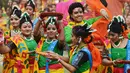 Sejumlah siswi menari selama perayaan Holi di Kolkata, India (7/3). Selama perayaan tersebut, peserta saling melemparkan bubuk berwarna-warni atau saling menyiramkan air berwarna-warni. (AFP/Dibyangshu)