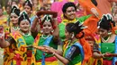 Sejumlah siswi menari selama perayaan Holi di Kolkata, India (7/3). Selama perayaan tersebut, peserta saling melemparkan bubuk berwarna-warni atau saling menyiramkan air berwarna-warni. (AFP/Dibyangshu)