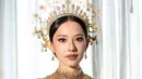 Ia mengenakan busana bernuansa keemasan rancangan Biyan dengan Tiara bagai serang Dewi. [Foto: Instagram/ The Bridestory]