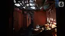 Warga membesihkan sisa barang dalam rumah yang terbakar di RW 02, Kelurahan Bidari Cina, Jakarta, Selasa (22/10/2019). Belum diketahui penyebab dari kebakaran yang menghanguskan pemukiman padat penduduk tersebut. (merdeka.com/Imam Buhori)