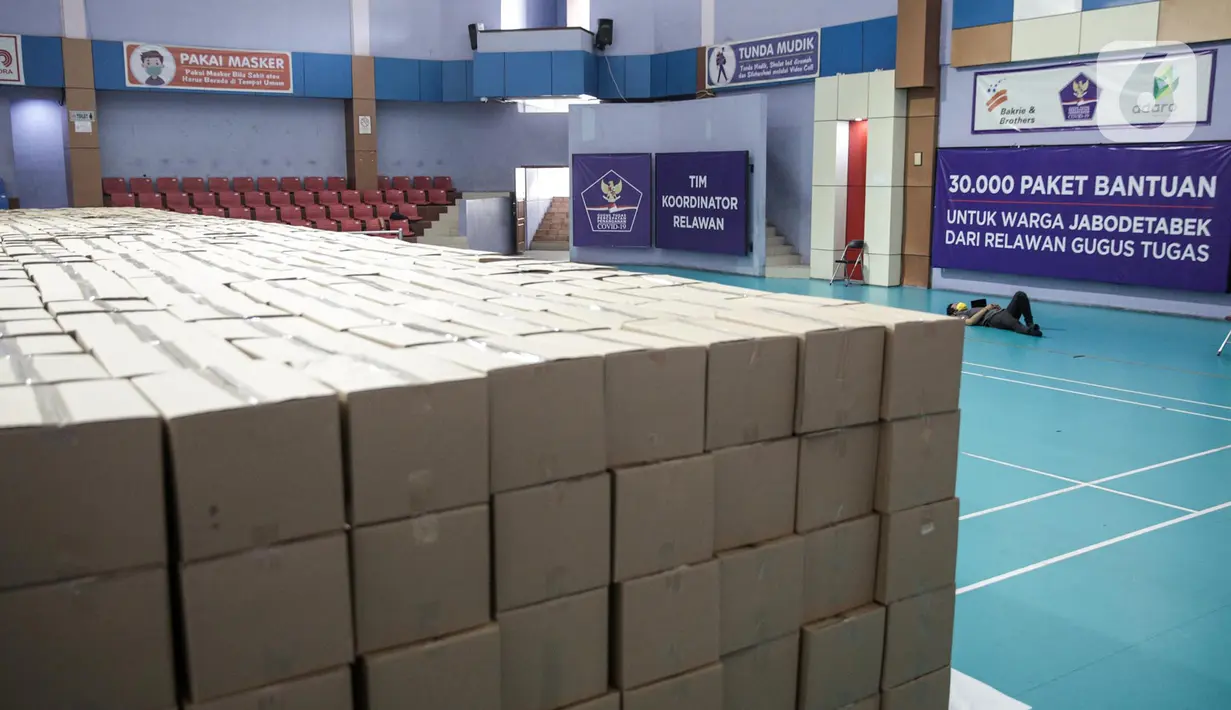 Relawan Gugus Tugas Percepatan Penanganan COVID-19 beristirahat di GOR Gelanggang Remaja, Jakarta, Senin (18/5/2020). Relawan Gugus Tugas Percepatan Penanganan COVID-19 membagikan 30.000 paket bantuan kepada warga Jabodetabek yang terdampak COVID-19. (Liputan6.om/Faizal Fanani)