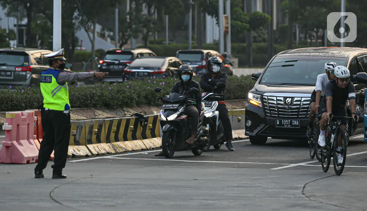 Polisi menghalau pesepeda yang berada di luar jalur di kawasan Sudirman-Thamrin, Jakarta Pusat, Rabu (2/6/2021). Sepeda road bike diperbolehkan untuk melintas di Jalan Sudirman-Thamrin pada hari kerja Senin-Jumat, namun dibatasi dari pukul 05.00-06.30 WIB. (Liputan6.com/Faizal Fanani)