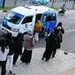 Para calon penumpang antre menunggu giliran untuk naik transportasi layanan angkutan umum JakLingko di Stasiun Klender Baru, Pondok Kopi, Jakarta, Senin (19/2/2024). (merdeka.com/Imam Buhori)