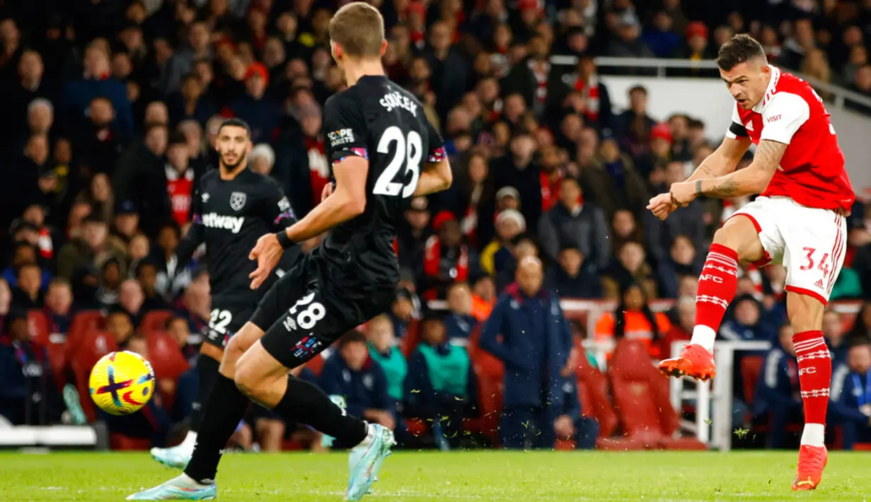 Pemain Arsenal Granit Xhaka (kanan) menendang bola saat melawan West Ham United pada pertandingan sepak bola Liga Inggris di Emirates Stadium, London, Inggris, 26 Desember 2022. Arsenal mengalahkan West Ham United dengan skor 3-1. (AP Photo/David Cliff)