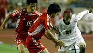 Rochy Putiray (putih) saat memperkuat Timnas Indonesia melawan Timnas China di fase grup Piala Asia 2004. (AFP/Frederic Brown)