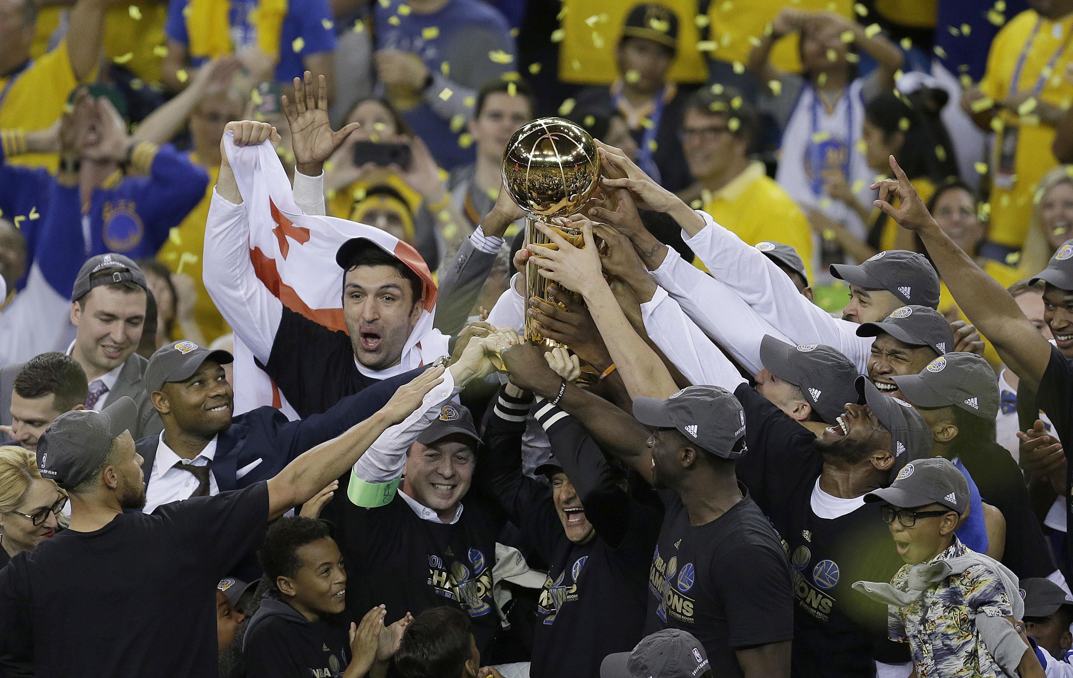 Para pemain Golden State Warriors mengangkat trofi juara NBA 2017 setelah pada laga final gim kelima mengalahkan Cleveland Cavaliers di di Oracle Arena, Oakland, (12/6/2017). Warriors menang 129-120.  (AP/Ben Margot)