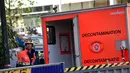 Petugas pemadam melewati ruang dekontaminasi di luar Masjid Agung Brussels, Belgia, setelah ditemukan paket berisikan serbuk putih yang dikhawatirkan Anthrax, Kamis (26/11). Petugas juga mengevakuasi 11 orang didekontaminasi. (AFP PHOTO/EMMANUEL Dunand)