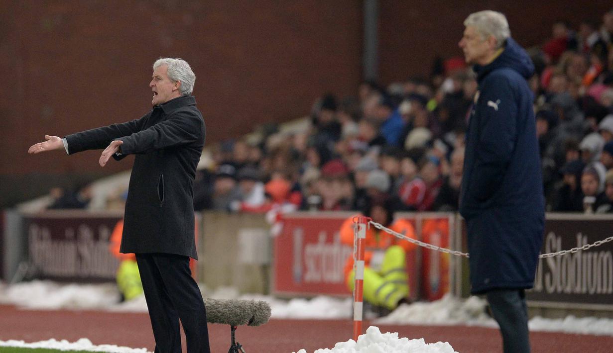 Pelatih Arsenal, Arsene Wenger (kanan) dan Pelatih Stoke City, Mark Hughes memberikan semangat kepada pemainnya pada lanjutan Liga Premier Inggris di Stadion Britannia, Stoke-on-Trent, Minggu (17/1/2016).  (AFP Photo/Oli Scarff)