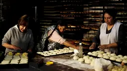 Para wanita saat membuat adonan roti untuk merayakan  peringatan All Saints di La Paz, Bolivia, Rabu (28/10/2015). Nantinya makanan - makanan ini akan dibawa ke pemakaman selanjutnya akan dilakukannya doa bersama. (REUTERS/David Mercadoâ)