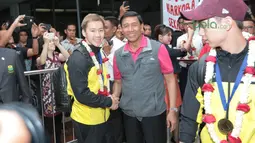 Marcus Gideon bersalaman dengan Ktum PBSI, Wiranto saat tiba di Bandara Soekarno-Hatta, Cengkareng, (20/3/2018). Kevin/Marcus mampu mempertahankan gelar All England 2018. (Bola.com/Nick Hanoatubun)