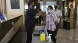 Petugas mengecek suhu tubuh pengunjung yang akan menginap di Hotel Grand Whiz Poins Simatupang, Jakarta, Kamis (16/4/2020). Di tengah pandemi virus corona COVID-19, hotel ini menyediakan paket isolasi mandiri selama 14 hari dengan harga Rp 6.500.000. (merdeka.com/Dwi Narwoko)