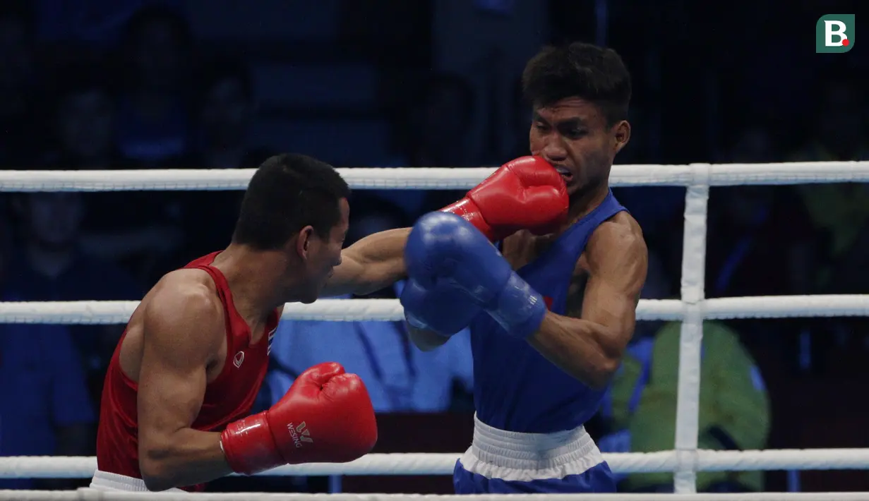 Petinju Indonesia, Farrand Papendang, beradu pukul dengan petinju Thailand, Khunatip Pidnuch, pada semifinal kelas 60 kg SEA Games 2019 di PICC Forum, Manila, Minggu (8/12). Farrand kalah dengan poin 139-146. (Bola.com/M Iqbal Ichsan)