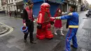Sejumlah peserta bersiap mengenakan kostum tokoh hiburan anak berjalan untuk mengikuti Hamleys Natal Toy Parade di Regent Street di London, Inggris (20/11). (AFP/Niklas Halle'n)