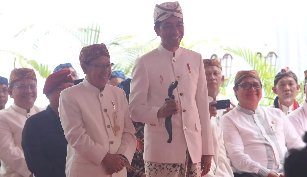 Presiden Joko Widodo (Jokowi) menerima kujang, senjata khas Sunda dalam prosesi penganugerahan gelar Pinisepuh dari Paguyuban Pasundan di Bandung, Minggu (11/11). Paguyuban Pasundan adalah ormas Sunda yang berdiri sejak 1913. (Liputan6.com/Angga Yuniar)