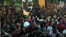 Sejumlah warga menonton pertandingan sepak bola Indonesia vs Malaysia di pertandingan Sea Games 2017 di Area Kementerian Pemuda dan Olahraga, Jakarta, Sabtu (27/8). Pada pertandingan tersebut Indonesia kalah 1-0 dari Malaysia. (Liputan6.com/Helmi Afandi)
