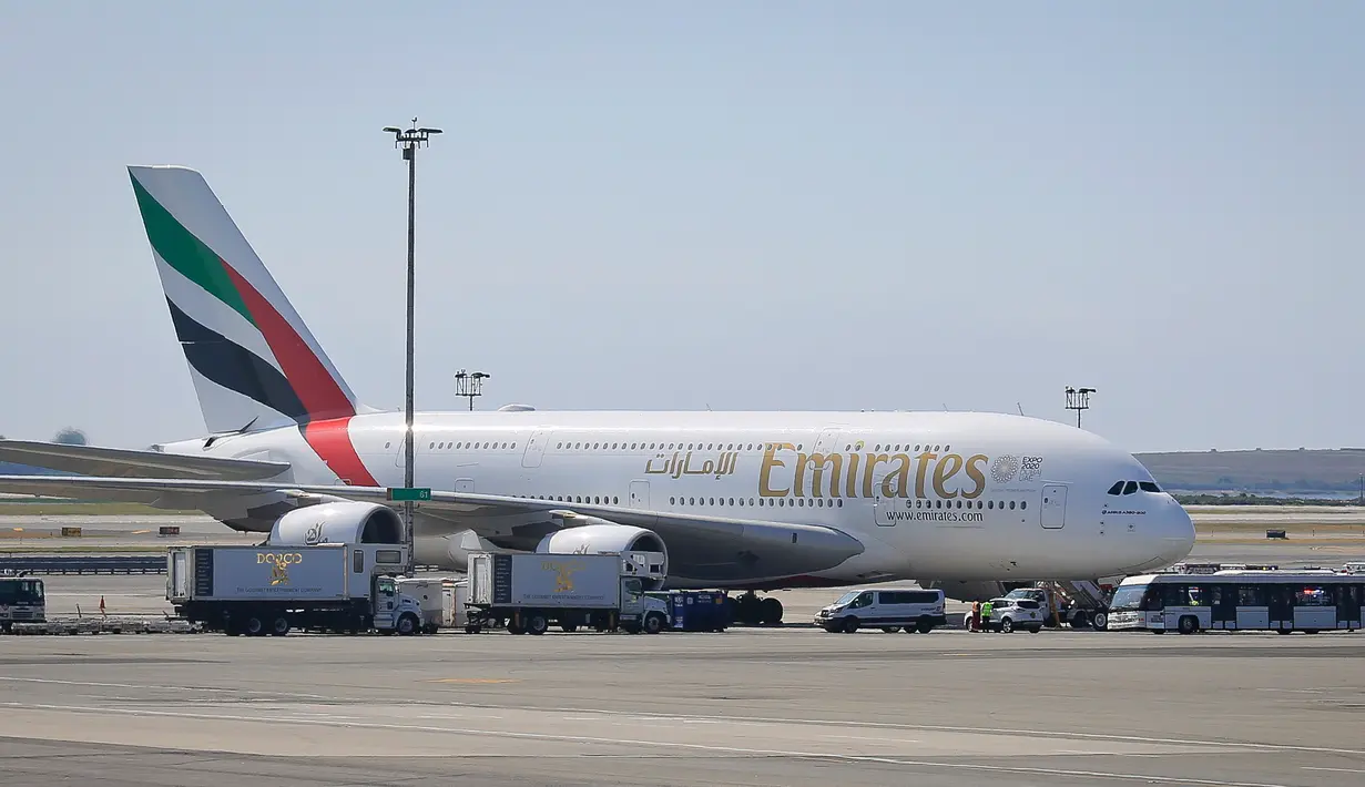Mobil dan petugas kesehatan mengepung pesawat setelah penumpang Emirates Airline dilaporkan sakit di Bandara Kennedy New York, Rabu (5/9). Belum ada keterangan resmi tentang penyakit yang dikeluhkan penumpang serta awak pesawat itu. (AP/Bebeto Matthews)