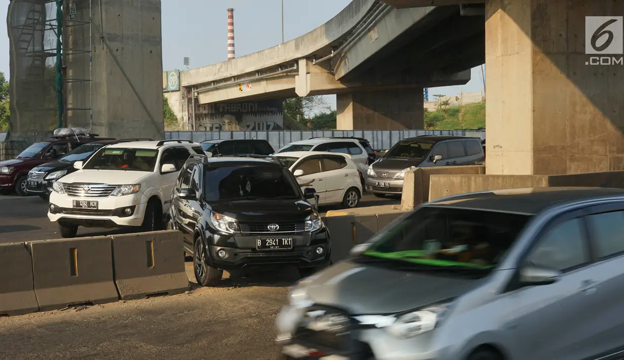 Sejumlah kendaraan menerobos pagar pembatas jalan tol di KM 30 Tol Jakarta - Cikampek, kawasan Cikarang, Jawa Barat, Minggu (9/6). Kemacetan yang terjadi di sepanjang jalur tersebut menyebabkan sebagian kendaraan nekat menerobos pagar pembatas untuk berpindah jalur. (Liputan6.com/Immanuel Antonius)