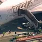 Petugas tanggap darurat berkumpul di luar pesawat setelah penumpang Emirates Airline dilaporkan jatuh sakit di Bandara Kennedy New York, Rabu (5/9). Sekitar 100 orang mengeluh sakit selama berada di pesawat dengan nomor penerbangan 521. (WABC 7 via AP)