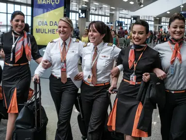 Awak maskapai penerbangan GOL Airlines saat berada di Bandara Internasional Tom Jobim, Rio de Janeiro, Brasil (8/3). Memperingati Hari Perempuan Internasional, GOL Airlines menghadirkan seluruh awak adalah wanita. (AFP PHOTO / Yasuyoshi Chiba)