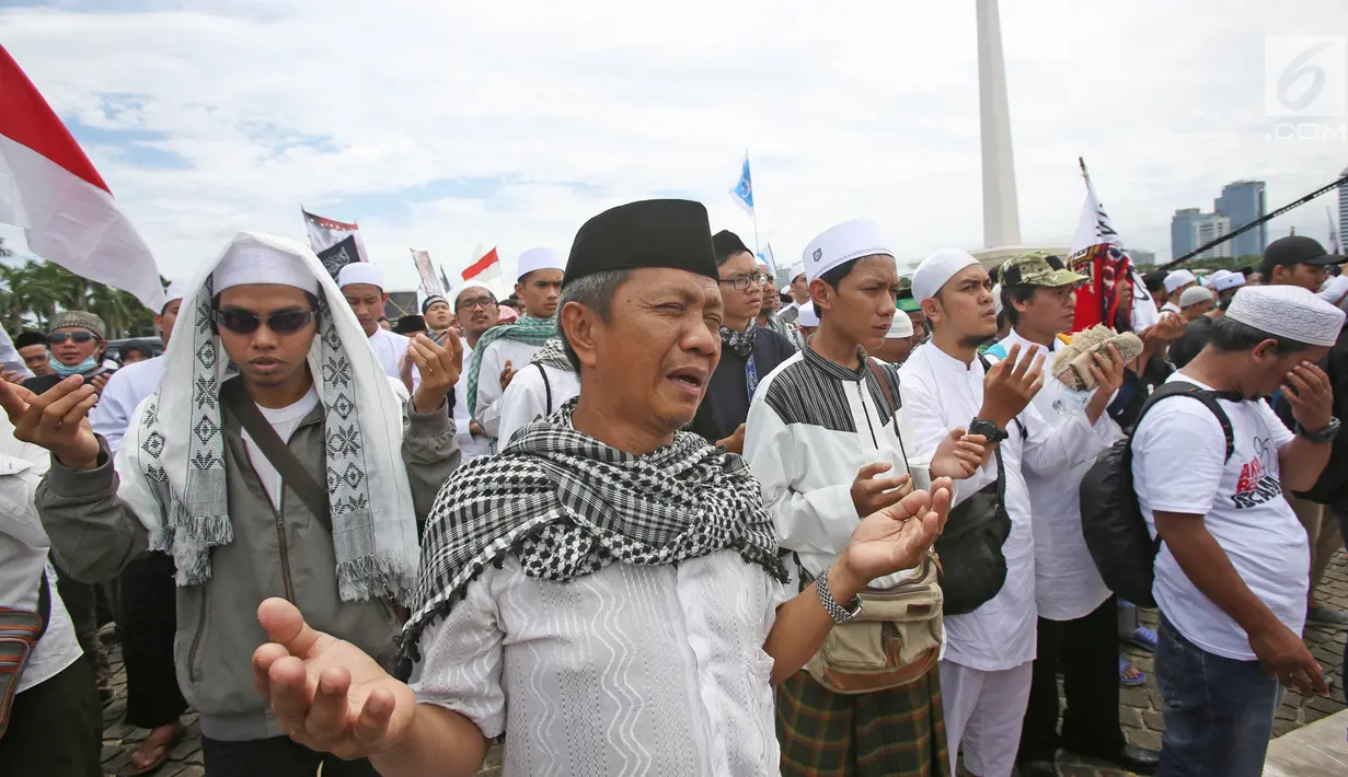 Massa berdoa bersama saat aksi Reuni 212 di kawasan Monas, Jakarta, Sabtu (2/12). Aksi yang diselenggarakan sebagai bentuk reuni kegiatan 2 Desember 2016 itu diisi dengan pembacaan zikir, salawat serta salat berjamaah. (Liputan6.com/Herman Zakharia)