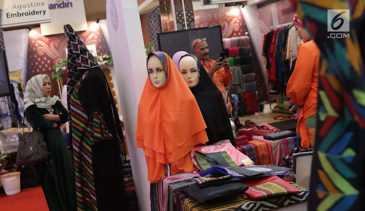 Pengunjung melihat-lihat stand pameran Gelar Kain Unggulan Nusantara di Jakarta Convention Center, Jumat (27/9/2019). Ratusan model kain dipamerkan dalam Gelar Kain Unggulan Nusantara yang berlangsung hingga Minggu, 29 September mendatang. (Liputan6.com/Helmi Fithriansyah)