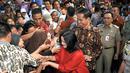 Presiden RI Joko Widodo beserta ibu Iriana disambut warga di sekitar Lapangan Bedeng, Pisangan Baru, Jakarta, Selasa (8/9/2015). Kedatangan Presiden Jokowi untuk memberikan sejumlah paket sembako dan buku kepada warga. (Liputan6.com/Helmi Fithriansyah)