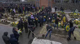 Keluarga dan teman menghadiri pemakaman seorang tentara yang tewas dalam perang dengan Rusia di pemakaman Lychakiv, Lviv, Ukraina, Selasa (5/4/2022). (AP Photo/Nariman El-Mofty)