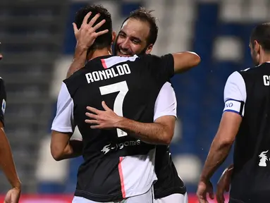 Penyerang Juventus, Gonzalo Higuain memeluk rekannya Cristiano Ronaldo usai mencetak gol ke gawanag Sassuolo pada pertandingan lanjutan Liga Serie A Italia di stadion Mapei di Reggio Emilia (15/7/2020). Juventus bermain imbang 3-3 atas Sassuolo. (AFP/Marco Bertorello)