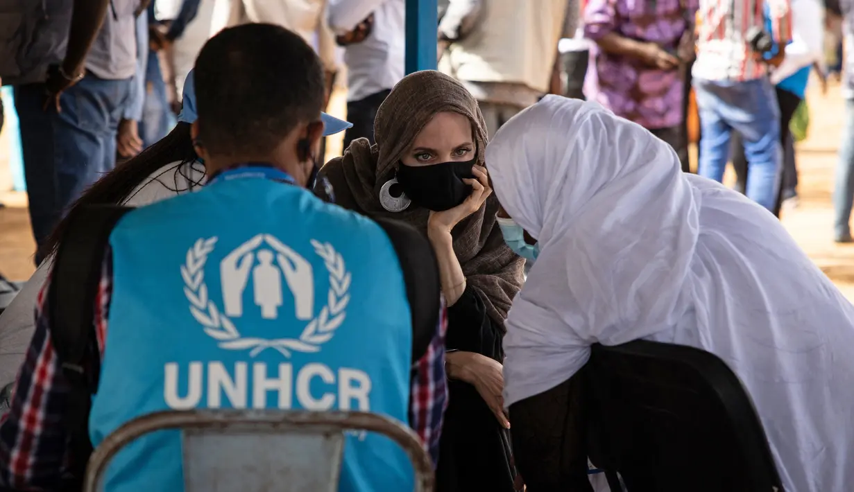 Aktris Angelina Jolie, utusan khusus PBB untuk UNHCR, berbincang dengan pengungsi Mali di kamp Goudebou, utara Burkina Faso, 20 Juni 2021. Jolie mengunjungi kamp pengungsi yang menampung ribuan warga Mali yang menyelamatkan diri dari kekerasan militan di kawasan itu. (OLYMPIA DE MAISMONT/AFP)
