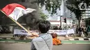 Aksi Bakar Tolak Reklamasi Pantai Ancol: Pengunjuk rasa  mengibarkan bendera merah putih didepan Balaikota, Jakarta, Rabu (8/7/2020). Mereka meminta Gubernur DKI Jakarta Anies Baswedan untuk menghentikan Reklamasi Pantai Ancol. (Liputan6.com/Faizal Fanani)