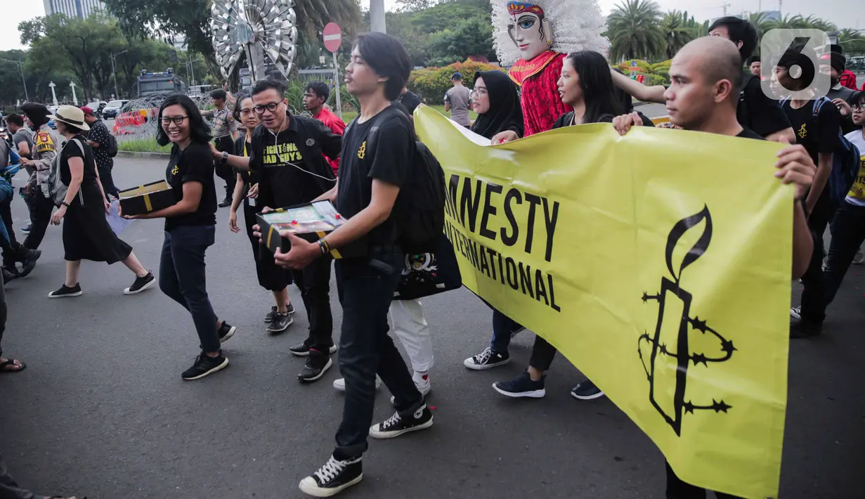 Aktivis yang tergabung dalam Amnesty Internasional Indonesia menggelar aksi di depan Istana Negara, Jakarta, Selasa (10/12/2019). Dalam aksi tersebut aktivis memberikan bingkisan kepada Sekretariat Kabinet yang berisi aspirasi masyarakat Indonesia untuk pemerintah. (Liputan6.com/Faizal Fanani)