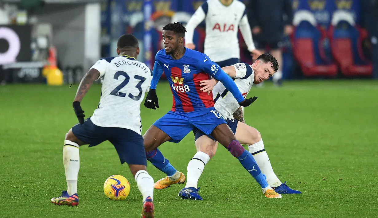 Striker Crystal Palace, Wilfried Zaha (tengah), dikurung dua pemain Crystal Palace dalam laga lanjutan Liga Inggris 2020/21 pekan ke-12 di Selhurst Park Stadium, Minggu (13/12/2020). Palace bermain imbang 1-1 dengan Tottenham. (AFP/Glyn Kirk/Pool)