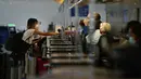 Seorang perempuan melakukan check in di Bandara Internasional Los Angeles di Los Angeles, California, 23 November 2020. Sekitar 1 juta orang Amerika memadati bandara dan pesawat menjelang libur Thanksgiving pekan ini bahkan saat kematian akibat COVID-19 melonjak. (AP Photo/Jae C. Hong)