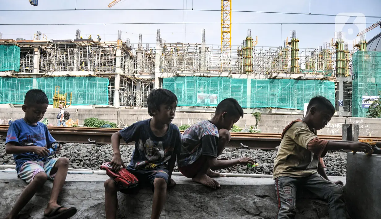 Anak-anak bermain di dekat proyek pembangunan Kampung Susun Bayam, Papanggo, Tanjung Priok, Jakarta Utara, Selasa (12/7/2022). Kampung Susun Bayam yang berada dekat dengan Jakarta International Stadium rencananya memiliki empat lantai yang diperuntukkan bagi 138 keluarga dan ditargetkan rampung pada September 2022. (merdeka.com/Iqbal S. Nugroho)