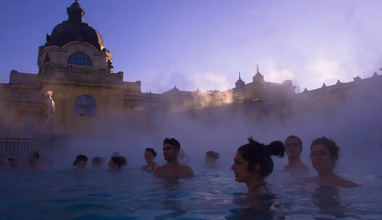 Pengunjung menikmati bersantai sambil berendam di kolam air panas Szechenyi Thermal Bath di Budapest, Hongaria, 7 Januari 2017. Szechenyi Thermal Bath adalah salah satu lokasi pemandian umum tertua dan terbesar di Budapest. (Bea Kallos/MTI via AP)