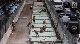 Pekerja menggarap penataan jalan dan trotoar di Jalan Sudirman, Jakarta, Selasa (17/4). Revitalisasi jalan dan trotoar tersebut sebagai persiapan Asian Games 2018 yang akan berlangsung di Jakarta pada Agustus 2018 mendatang. (Liputan6.com/Arya Manggala)