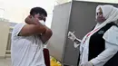 Reaksi seorang siswa SMA saat menerima dosis vaksin virus corona COVID-19 Pfizer di Rumah Sakit Zainoel Abidin, Banda Aceh, Aceh, Selasa (9/11/2021). Vaksinasi COVID-19 di kalangan warga Kota Banda Aceh tembus 80 persen. (CHAIDEER MAHYUDDIN/AFP)