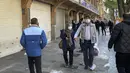 Orang-orang berjalan di depan toko-toko yang tutup di Grand Bazaar Teheran saat polisi anti huru-hara mengontrol lokasi protes, Iran, Selasa (15/11/2022). Etalase toko yang tertutup dapat dilihat di seluruh Teheran, pada hari Selasa. (AP Photo/Vahid Salemi)